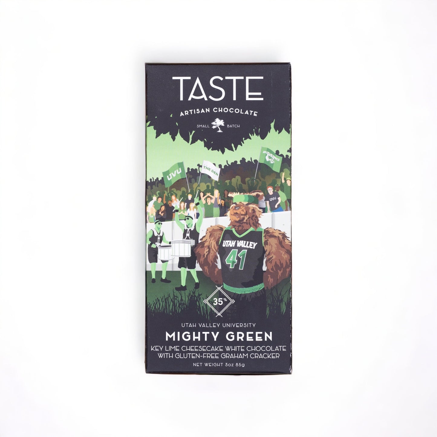 A packaged chocolate bar with the brand name TASTE on the top, and a graphic of a character resembling a bear wearing a student cap in front of a university setting backdrop. The product is named 'Mighty Green' and lists ingredients such as cacao, organic cane sugar, and honeycomb.